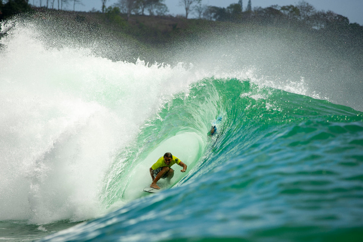 A surfer riding deep inside a green barrel
